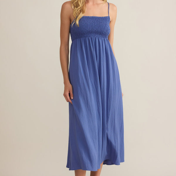 front view of the model wearing the beachside midi dress. shows the square neckline. also shows the midi length, the adjustable spaghettis straps, and this beautiful blue color. 