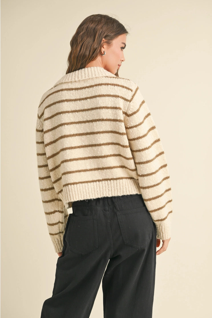 back view of the model wearing the arlette button down striped knitted cardigan. shows the ribbed detailing, the collar and the stripe pattern. 