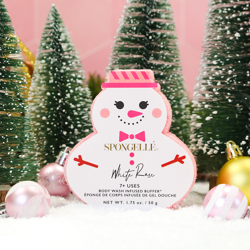 shows trees and ornaments in the background. shows the snowman buffer soap. its in the shape of a s nowman with the features of a snowman on the packaging. shows the color light pink, dark pink and white. 