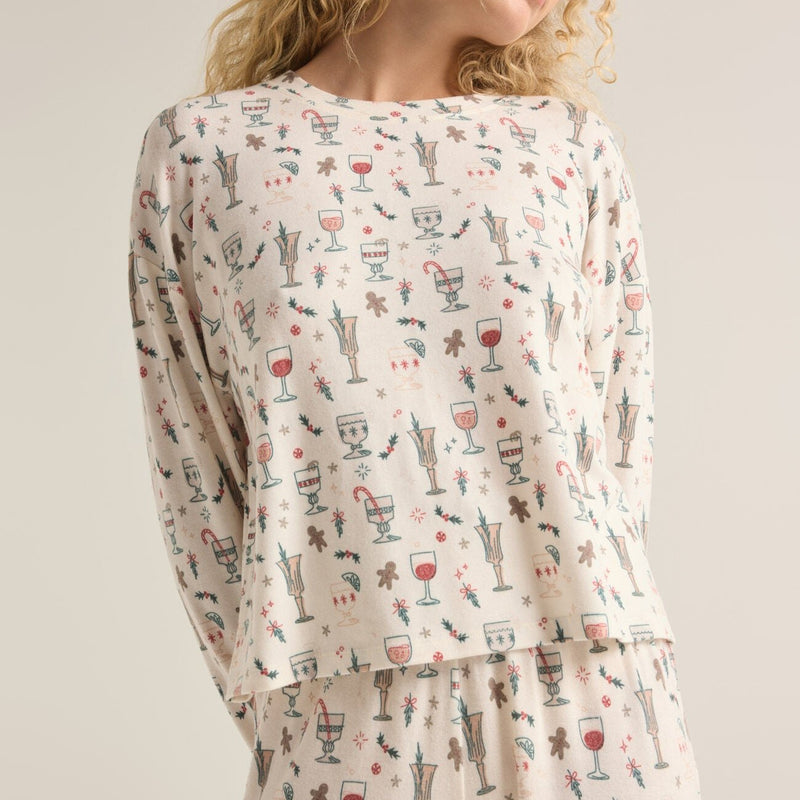 front view of the model wearing the holiday spirits long sleeve top. shows the crew neckline. also shows the the christmas print, the regular fit and dropped shoulders. 