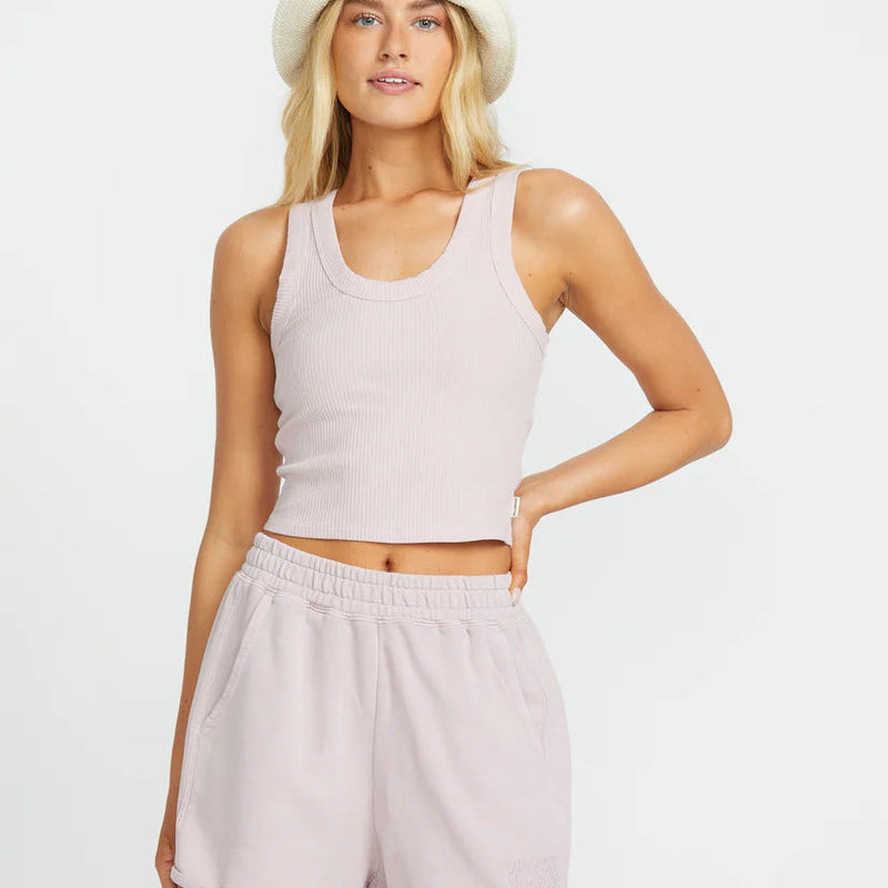 front view of the model wearing the rerun tank. shows the scoop neckline. also shows the thick straps, the cropped length and the ribbed detailing. 