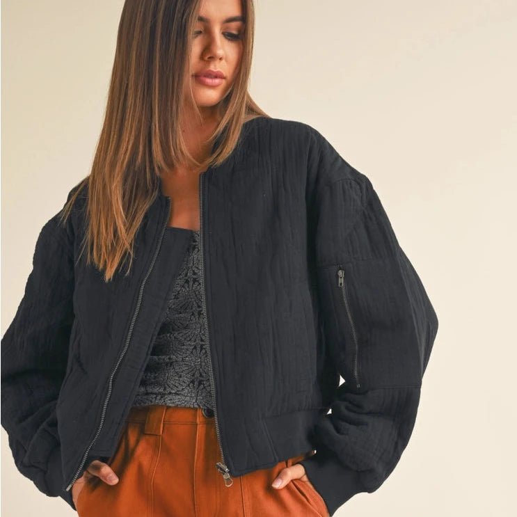 front view of the norah quilted gauze bomber jacket. shows the front zipper closure. also shows the zipper detail on the sleeve, the crew neckline and the front pockets. 