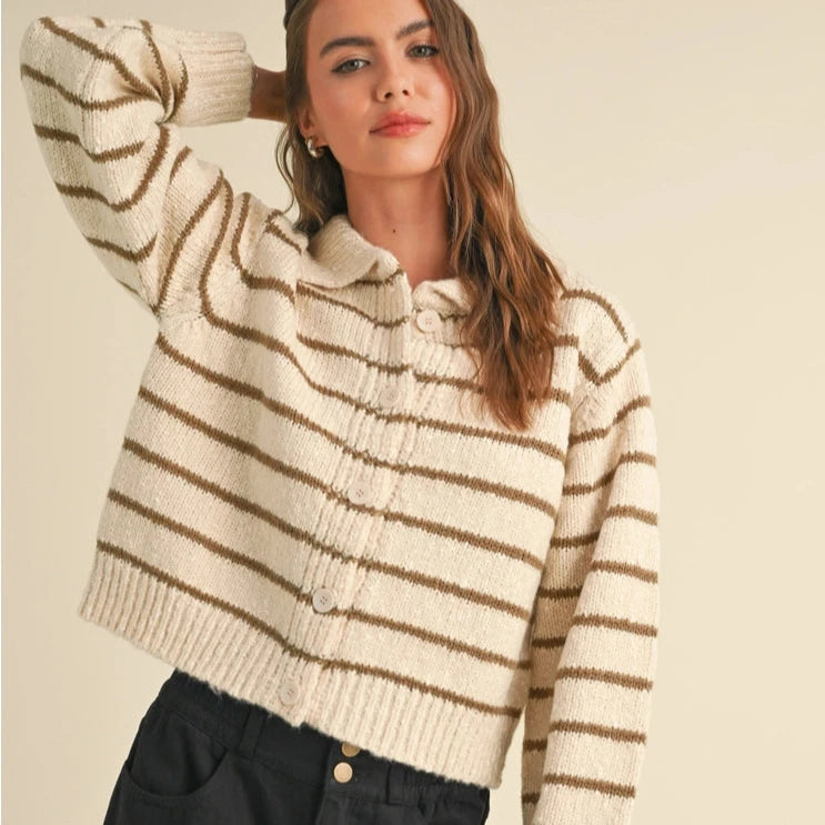 front view of the model wearing the arlette button down striped knitted cardigan. shows the traditional collar. also shows the button down closure, the ribbed detailing and the striped pattern.  