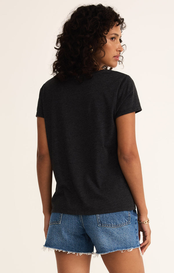 back view of the model wearing the anywhere scoop tee. shows the relaxed fit. also shows black color and the short sleeves. 