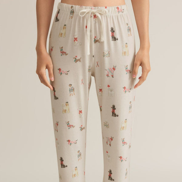 front view of the model wearing the best friend joggers. shows the elastic waistband with tie. also shows the mid-rise and the dog print throughout. 