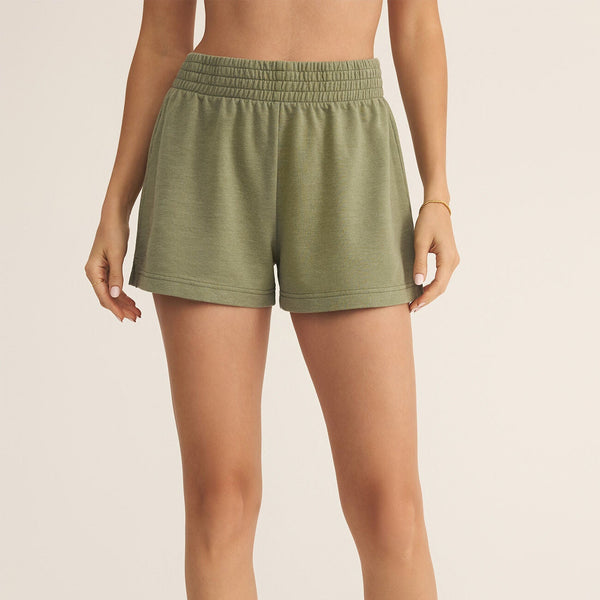 front view of the model wearing the weekender short.  shows the elastic waistband. also shows the pull on style, the green color and the high rise waist. 