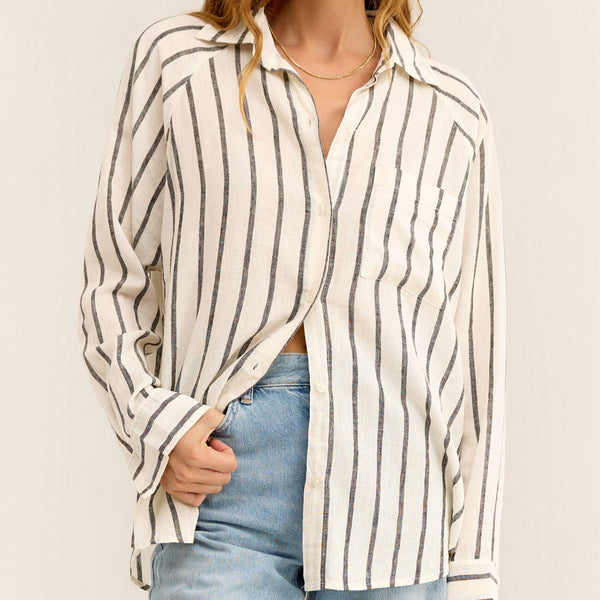 front view of the model wearing the perfect line top. shows the collar. also shows the button down closure, front patch pocket and the oversized fit. 