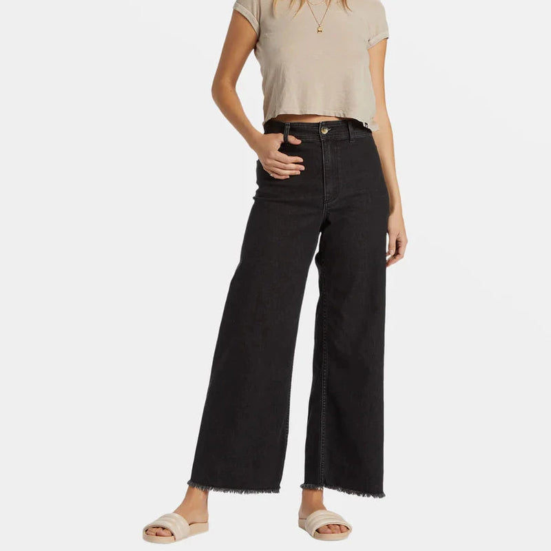 front view of the model wearing the free fall high waisted pants. it shows that they are high waisted. also shows the wide leg, the button and zipper closure and the belt loops. 