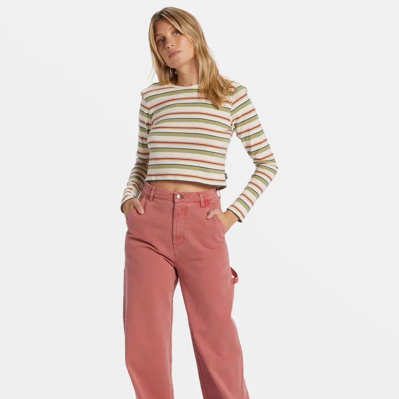 front view of the model wearing the tommy stripe long sleeve top. shows the stripe pattern. also shows the colors of green, cream, and a pinkish color, the crew neckline and the cropped length. 