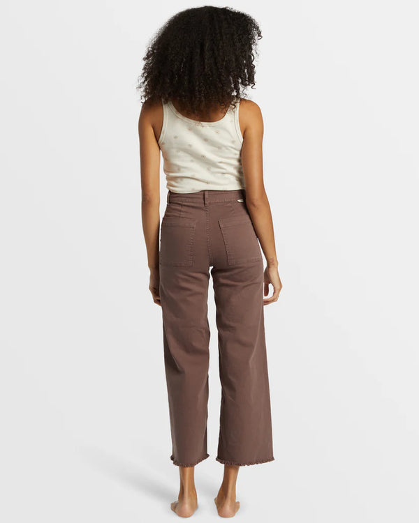 back view of the model wearing the free fall high waist pants. shows the back square pockets. also shows the high waist, the bottom frayed hem, the wide, cropped legs. 