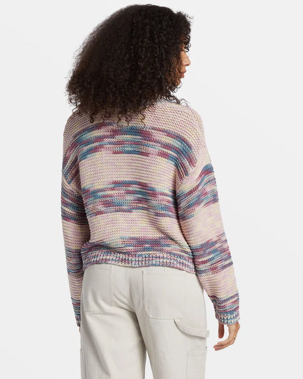 back view of the model wearing the fade out pullover sweater. shows the dropped shoulders. also shows the ribbed detailing on the sleeves and bottom hem, the relaxed fit and the multicolored striping throughout. 