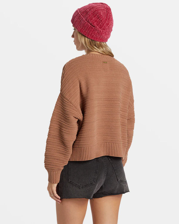 back view of the model wearing the evie sweater. shows the dropped shoulders. also shows the relaxed fit and rib stitch detailing. 