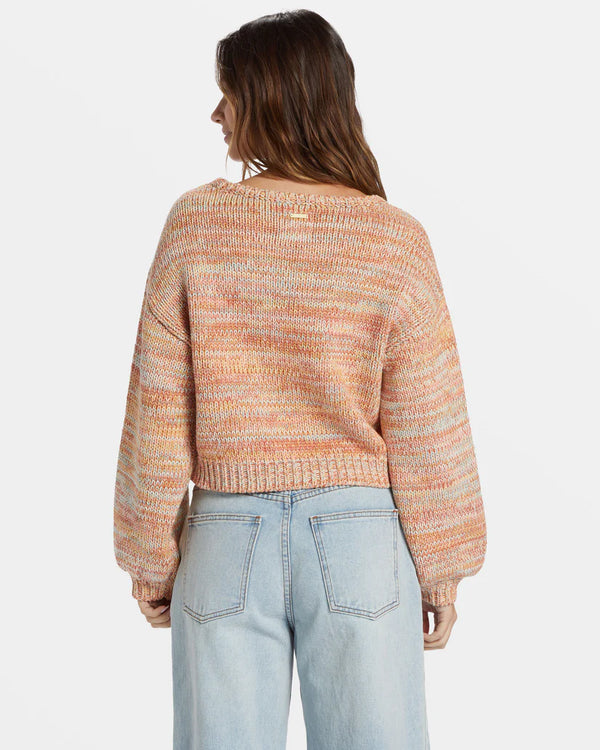 back view of the model wearing the vivid sun pullover sweater. shows the wider sleeve. also shows the relaxed fit, the waist length and the dropped shoulders. 