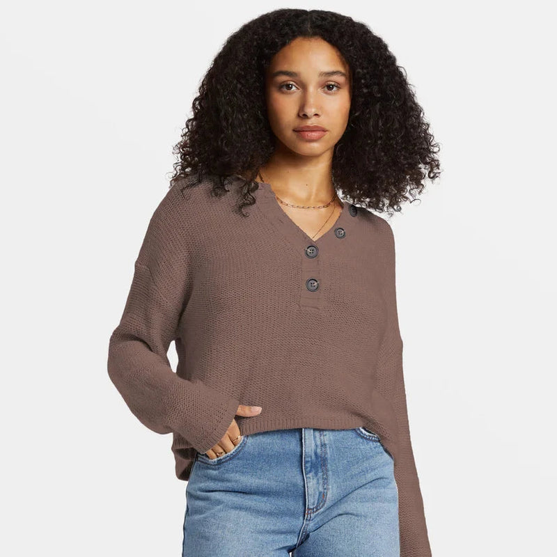 front view of the model wearing the shallow waters henley sweater. shows the crew neckline. also shows the neckline button closure, the dropped shoulders and the ribbed detail on the bottom hem. 