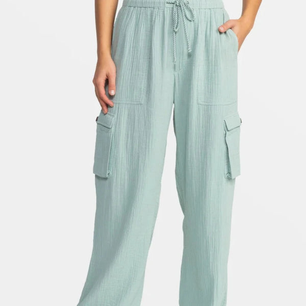 front view of the model wearing the precious beach high waist cargo pants. shows the twisted drawcord closure. also shows the front pockets, the side cargo pockets and the elastic waist. 