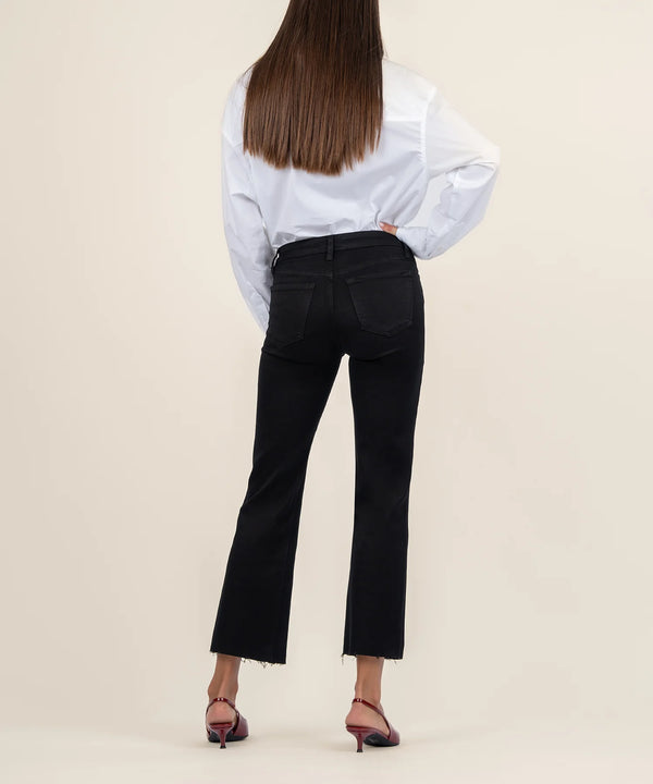 back view of the model wearing the kelsey mid rise ankle flare jeans. shows the back pockets. also shows the bottom raw hem and the flare bottoms.