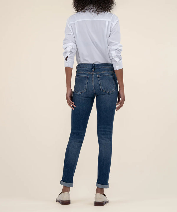 back view of the model wearing the catherine mid rise boyfriend jeans. shows the dark wash. also shows the  back pockets, the mid rise and the bottom rolled cuffs. 