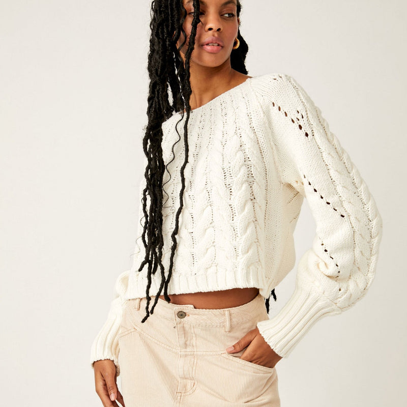 Front view of model wearing pullover. Shows the scoop neckline. Also shows the cropped fit and the exaggerated sleeves. 