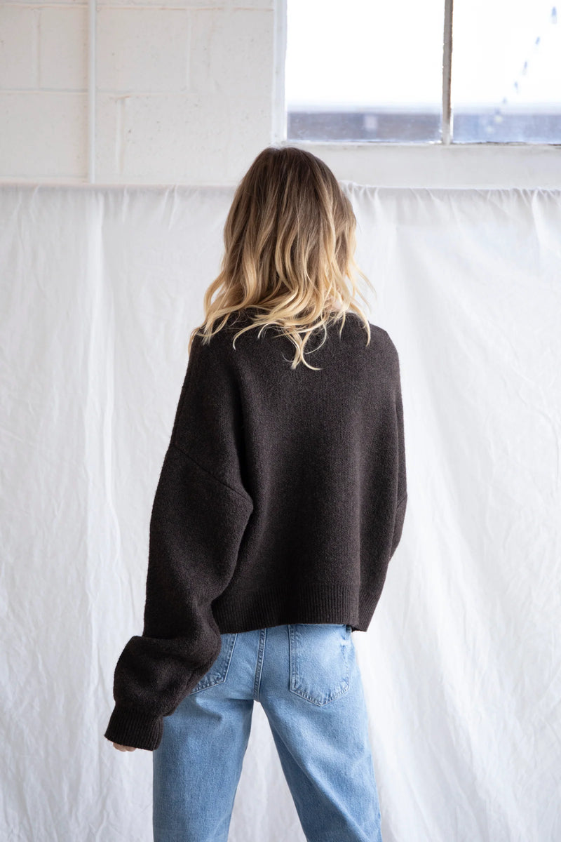 back view of the model wearing the alyssa cardigan in this beautiful chocolate brown color. shows the dropped shoulders. also shows the oversized sleeves, and the relaxed fit. 