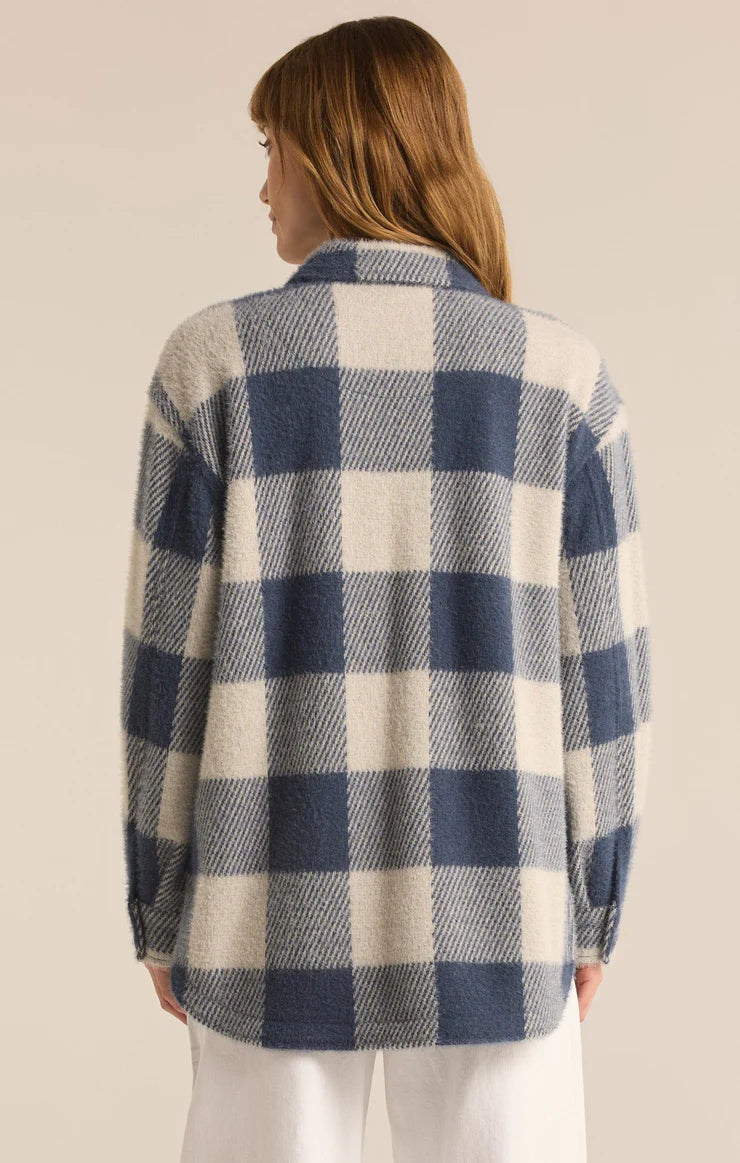 back view of the model wearing the tucker buffalo check jacket. show the collar. also shows the button closure on the cuffs, and the curved bottom hem. 