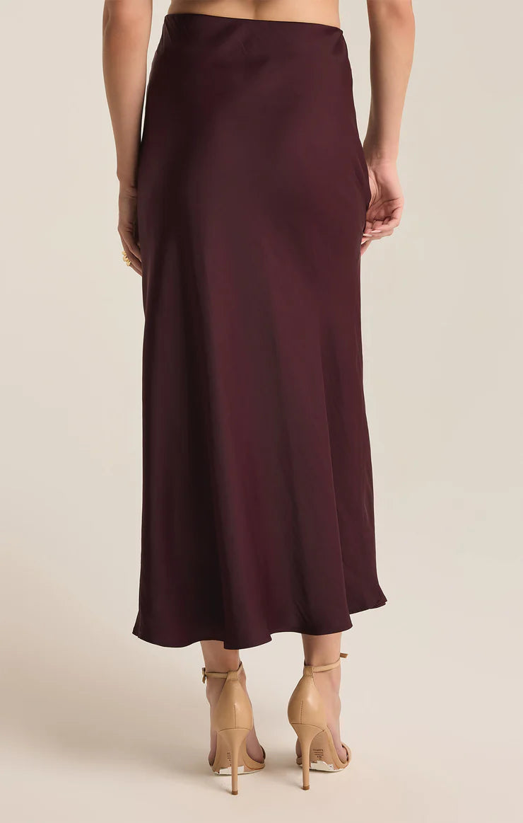 back view of the model wearing the europa midi skirt. shows the elastic waistband. also shows the midi length and the slight ruffle on the bottom. 