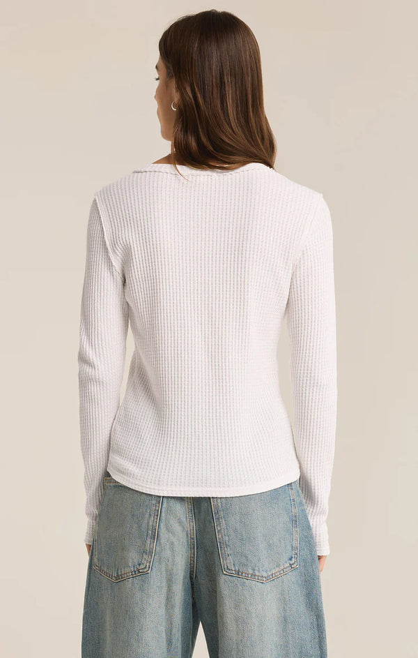 back view of the model wearing the arlet thermal top. shows the long sleeves. also shows the raw edge hems and the crew neckline. 