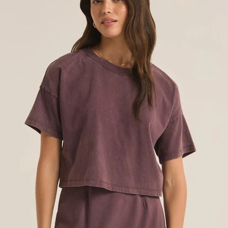 front view of the model wearing the sway cropped tee. shows the cropped length. also shows the dropped shoulders. the crew neckline and the mineral wash. 