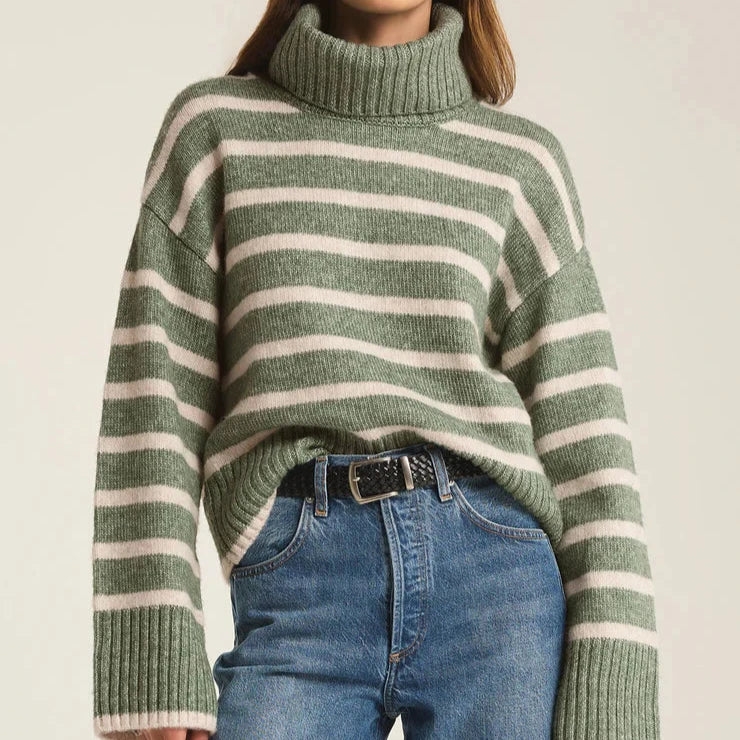 front view of the model wearing the josephine stripe sweater. shows the turtleneck. also shows the wider sleeves, ribbed detailing and dropped shoulders. 