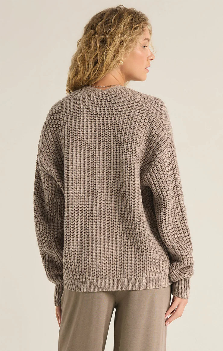 back view of the model wearing the sutton rib cardigan. shows the dropped shoulders. also shows the ribbed detailing and the regular fit. 