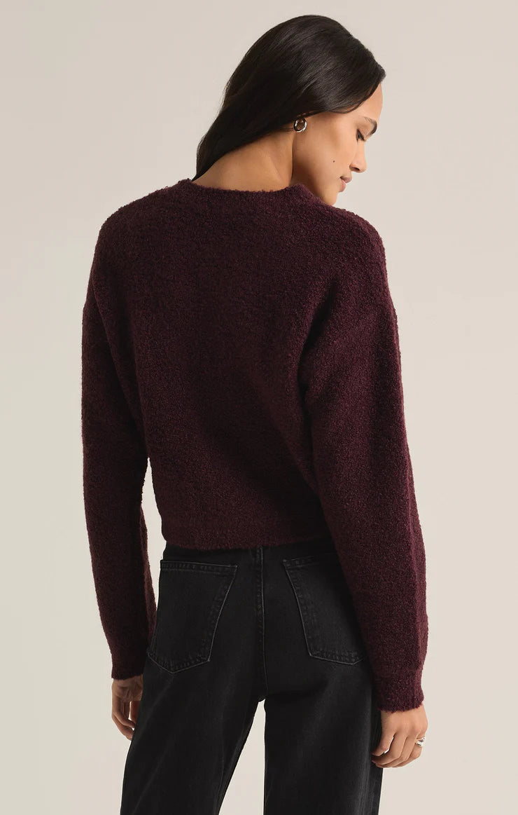 back view of the model wearing the destiny sweater. shows the ribbed detailing on the cuffs, neckline and the bottom hem. also shows the crew neckline and the dropped shoulders. its shows the color of berry. 