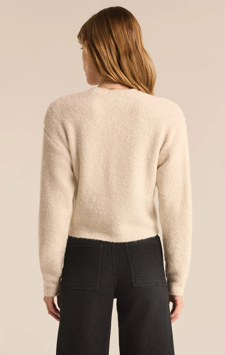 back view of the model wearing the destiny sweater. shows it in this winter white color. also shows the dropped shoulders, the fuzzy material and the waist length. 