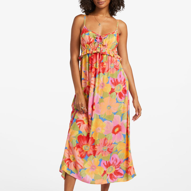 shows front view of model in dress. showcases spaghetti straps, wide v-neckline, cinched bodice with tie detail and ruffles. shows the midi length and all over floral print. 