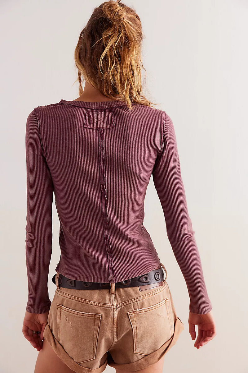 back view of the model wearing the its on cardi. shows the exposed seams. also shows the slight scoop neckline, the fitted long sleeves and the ribbed detailing. 