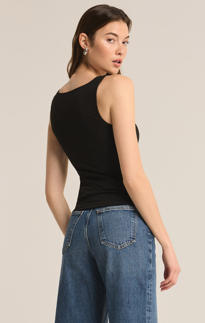 back/side view of the model wearing the avala v neck so smooth top. shows the high back neckline. also shows that the tank is fitted and tuckable. 