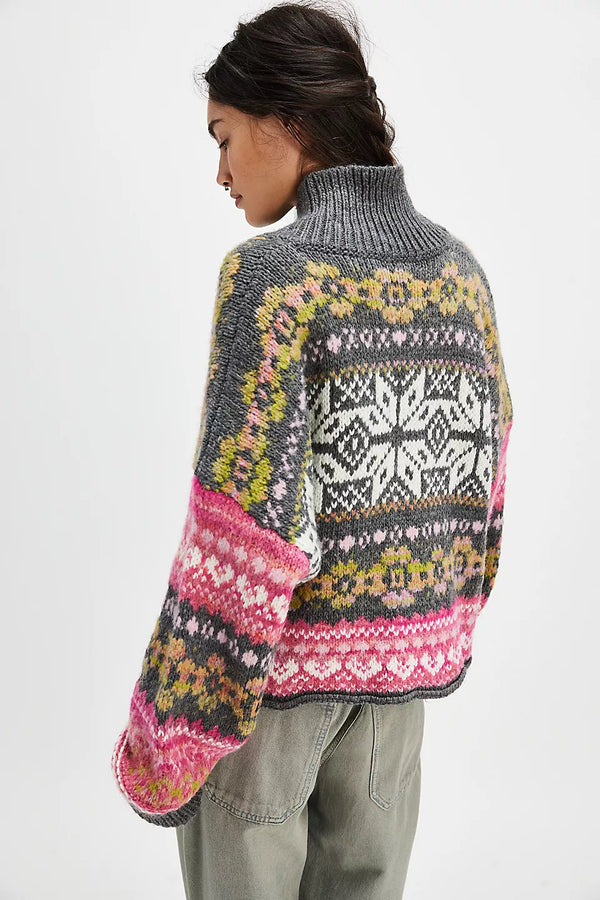 back view of the model wearing the snowdrift cardigan . shows the fairisle pattern. also shows the collared neckline the oversized fit and the ribbed trim. 