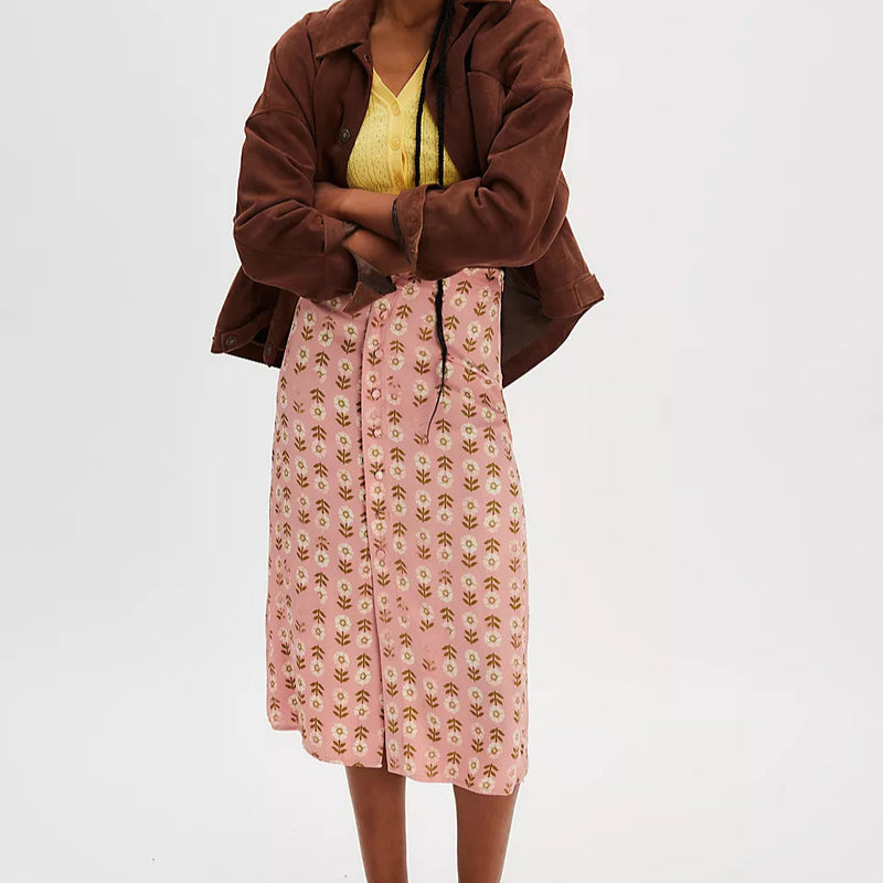 front view of the model wearing the analise printed midi skirt. shows the button down design the front. also shows mid - rise silhouette, side zipper and all over flower pattern. 