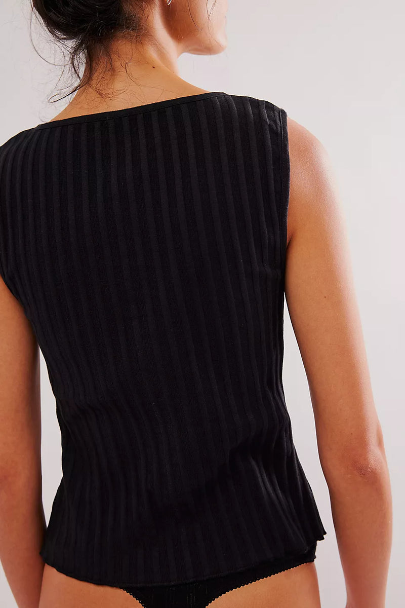 back view of the model wearing the tilly vest. shows the vest ribbed detailing, also shows the black color. 