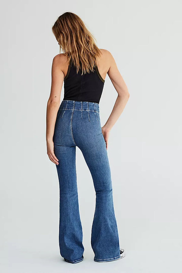 back view of the model wearing the jayde flare jeans. shows the exposed yolking throughout. also shows the flared silhouette and the high rise waist.   