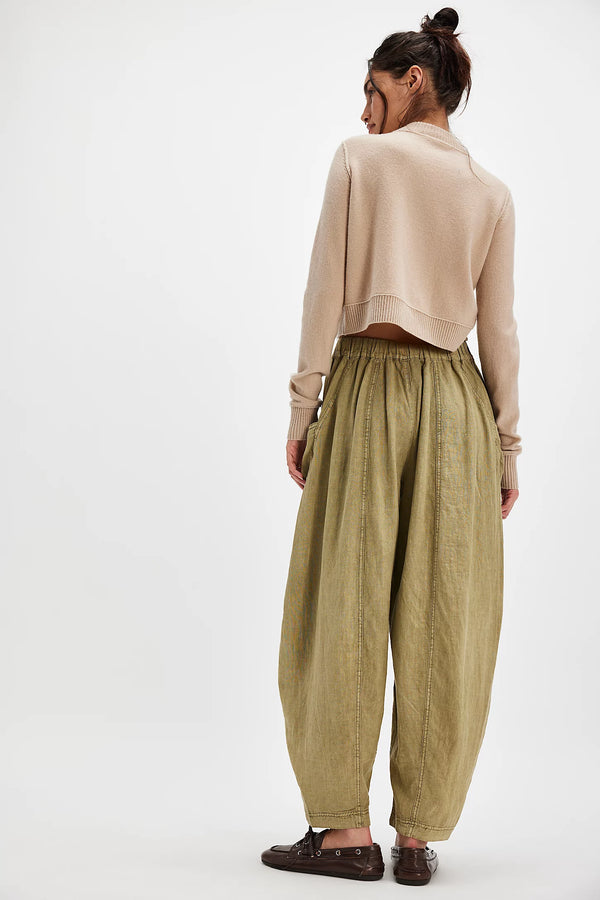 back view of the model wearing the high road solid pull on barrel pants. shows the ankle length. also shows the pull on style, the mid rise waist and the defined seaming down the pant legs. 