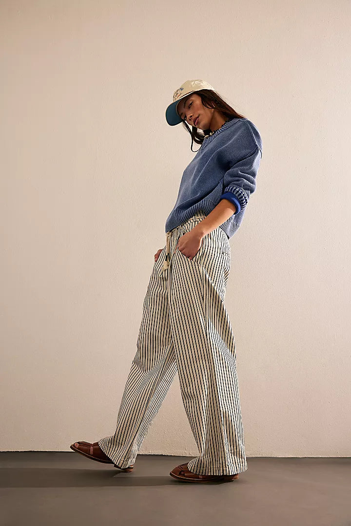 side view of the model wearing the dakota cinched pull railroad jeans. shows the stripe design. also shows the wide leg and the front and back pockets.