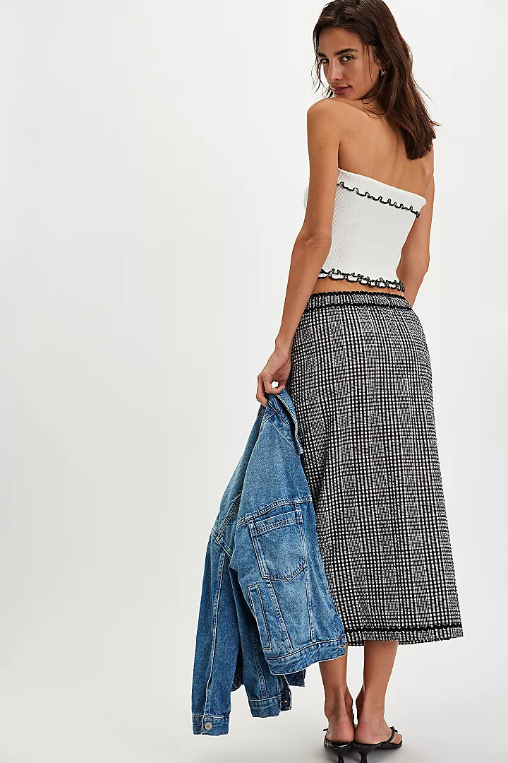 back view of the model wearing the penelope gingham midi skirt. shows the pull on style. also shows the midi length, the mid-rise and the checkered black and white print. 