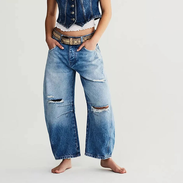 front view of the model wearing the good luck mid-rise barrel jeans. shows the subtle distressing. also shows the tapered legs, the wife legs and the seam detail throughout. 