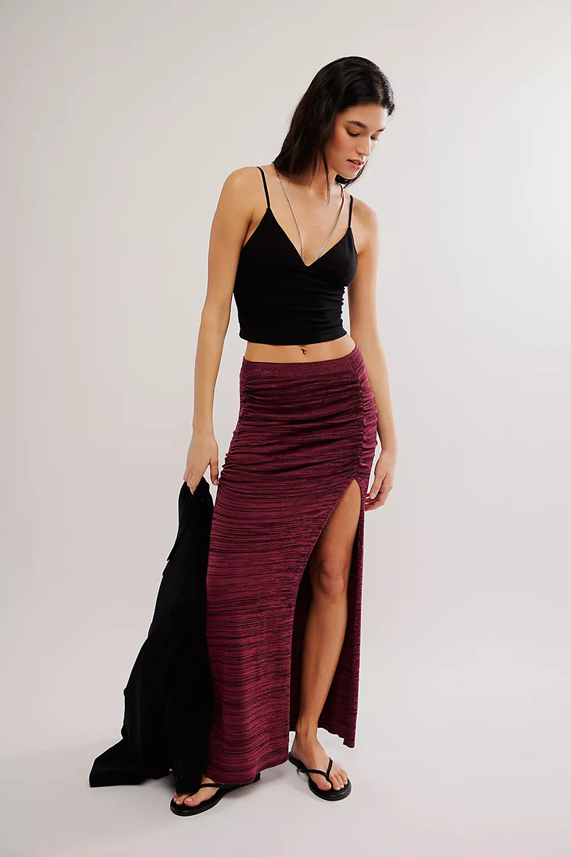 front view of the model wearing the peak show maxi skirt. shows the pull on design. also shows the rouched side, the high slit and maxi length. 