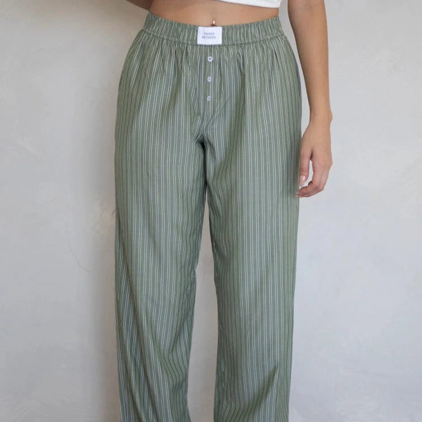 front view of the model wearing the gia boxer pant. shows the high waist. also shows the stripe design, the three button detail, and the elastic waistband. 