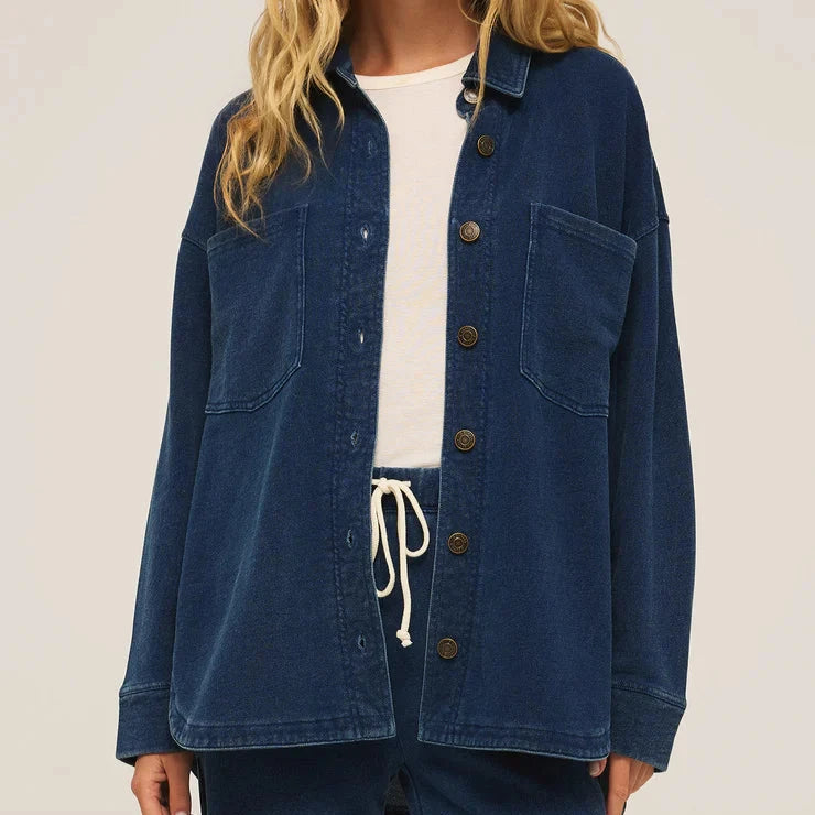 front view of the model wearing the all day knit denim jacket. shows the button down front closure. also shows the collar, the oversized fit and the front patch pockets. 