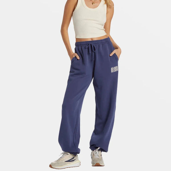 front  view of the model wearing the palmin elastic waist joggers. shows the drawstring closure. also shows the logo on the left leg, the elastic leg opening and the mid rise. 