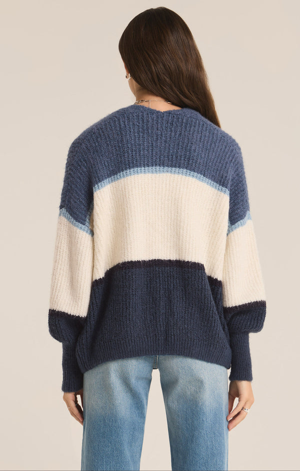 back view of the model wearing the jones stripe cardigan. shows the full blouson sleeves. also shows the ribbed detailing and the color blocking.  