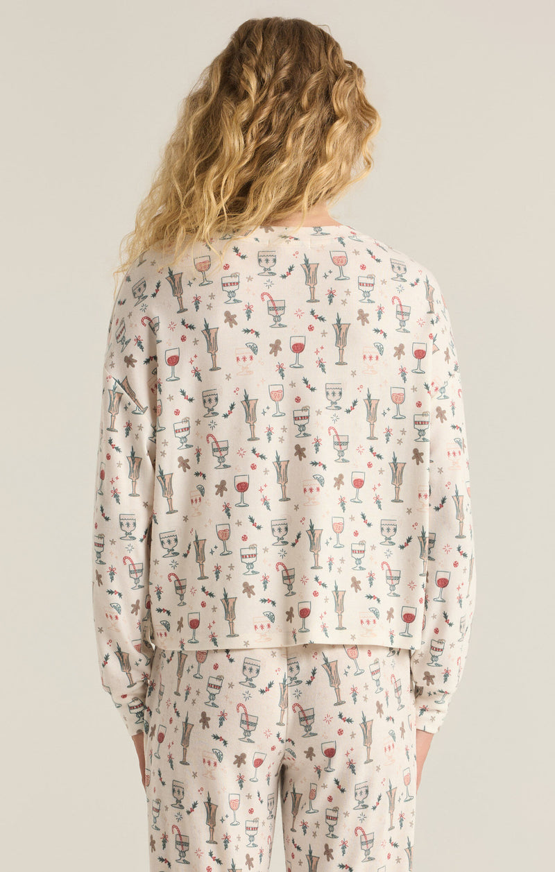 back view of the model wearing the holiday spirits long sleeve top. shows the fun christmas pattern. also shows the long sleeves, the dropped shoulders and the regular fit. 