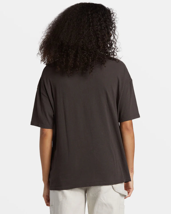 back view of the model wearing the natural mystic t shirt. shows the short sleeves. also shows the oversized fit and the dropped shoulders. 