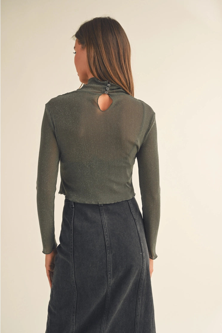 back of the lisa mesh sparkle long sleeve. shows the keyhole by the neckline. also shows the button closure on the neck, the semi ruffle on hem and cuffs and the cropped length. 